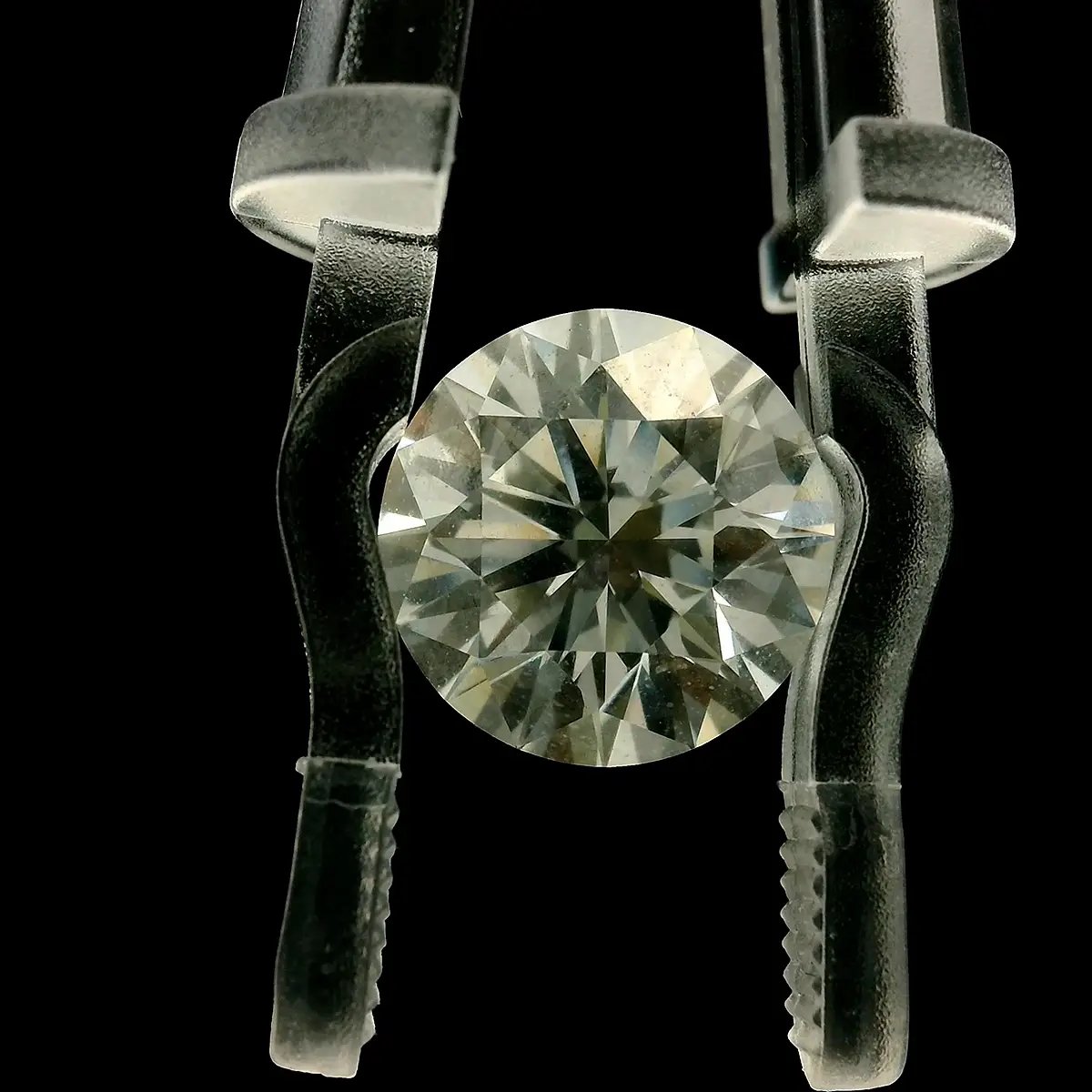 A loose diamond in a Gem Clip on a black background