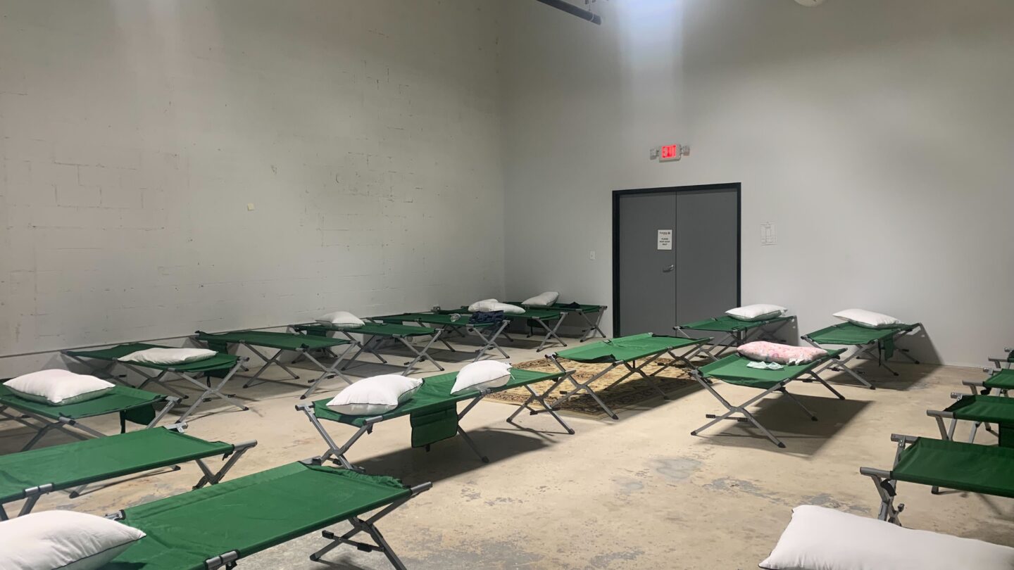 Empty cots in sparse room