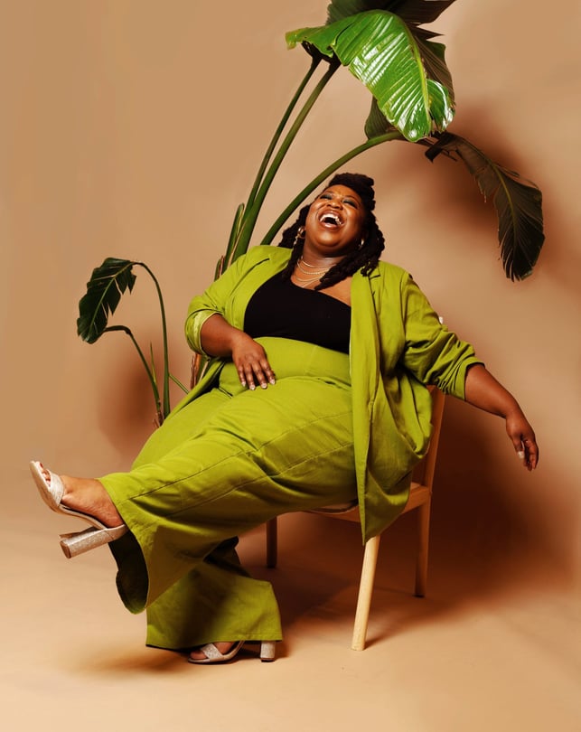 poet aurielle marie laughing in a chair
