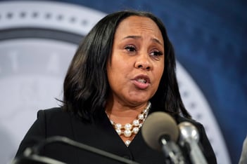 Fulton County District Attorney speaks into a microphone.