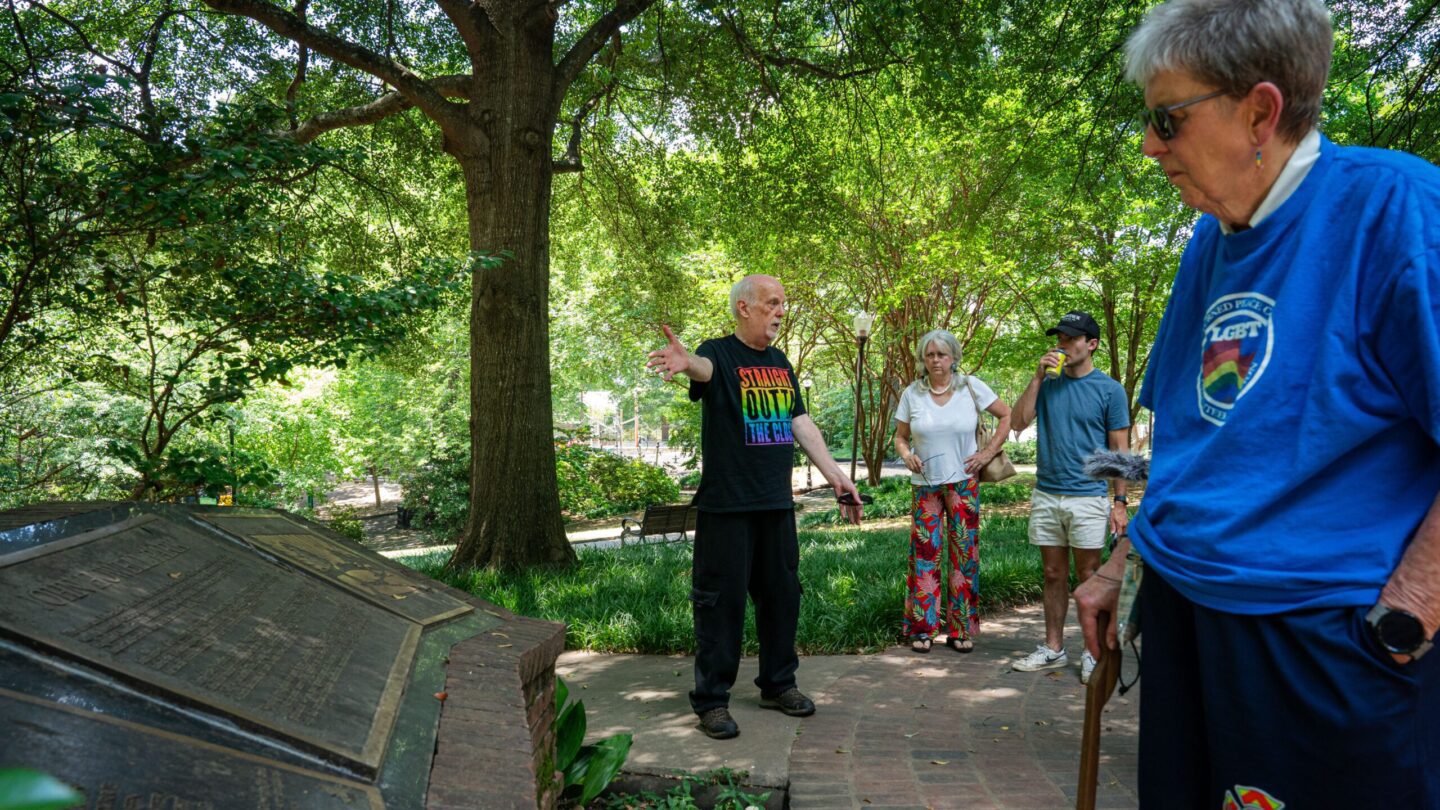 Older man ouside speaking to small crowd