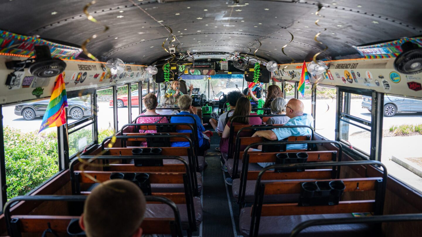 Passengers inside pride decorated bus