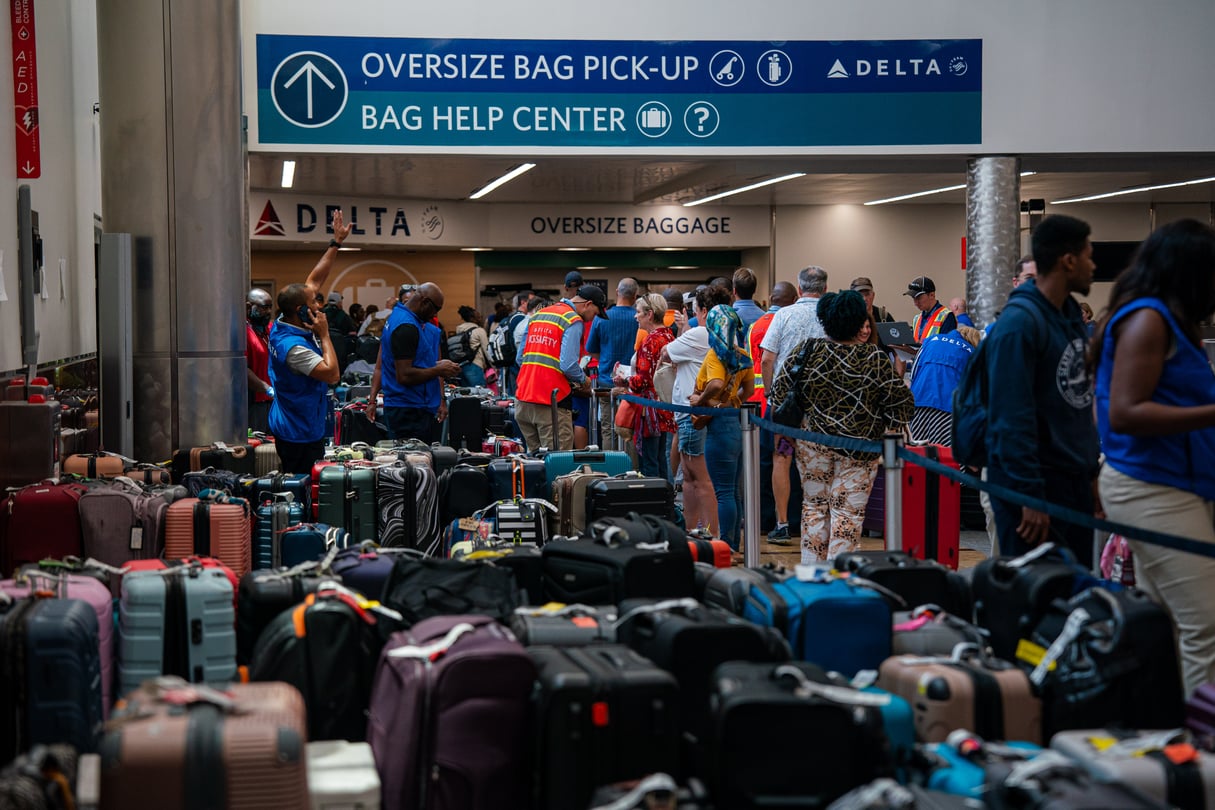 Luggage covers the floor of baggage claim at Atlanta's Hartfield-Jackson Airport as Delta employees try to reunite passengers with their belongings.