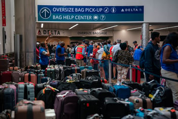 Luggage covers the floor of baggage claim at Atlanta's Hartfield-Jackson Airport as Delta employees try to reunite passengers with their belongings.