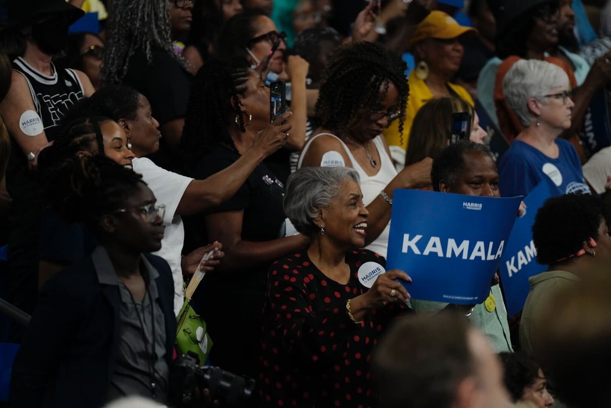 Rallygoers at Kamala Harris' campaign rally in Atlanta hold up signs and cheer.