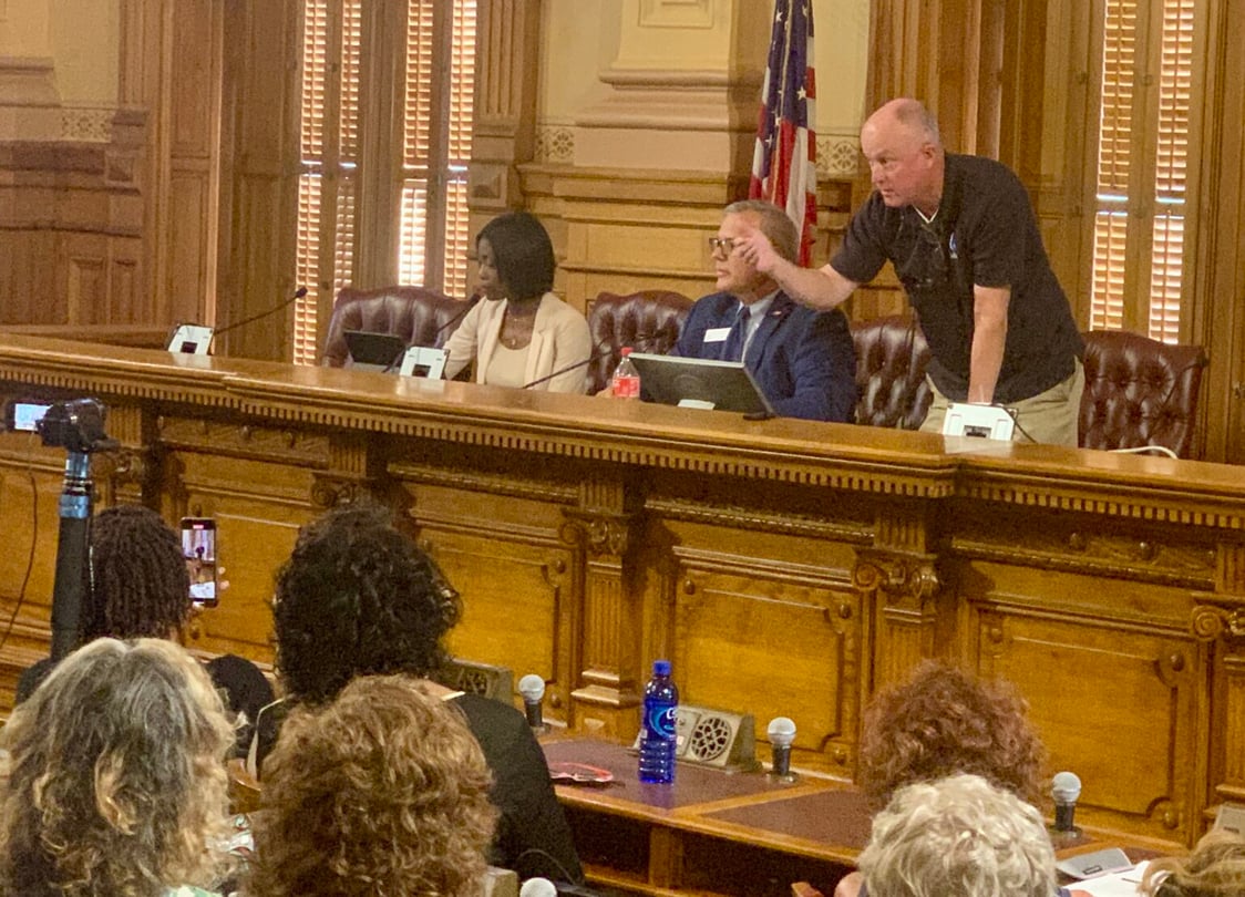 Board member Rick Jeffares, right, threatens to remove people for being disruptive.