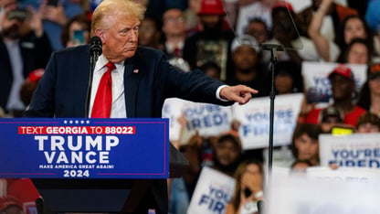 Former President Donald Trump points at the crowd at his campaign rally in Atlanta on Saturday, Aug. 3, 2024.