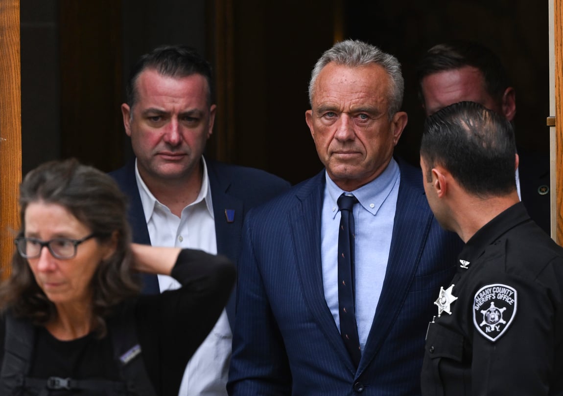 Robert F. Kennedy Jr. exits a courthouse surrounded by others.