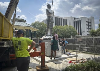 A large lift installs a statue of late civil rights leader and politician Congressman John Lewis.