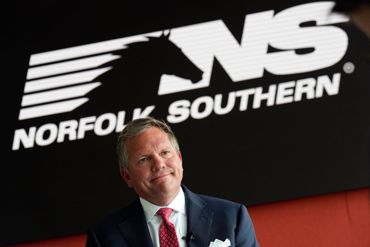 Norfolk Southern Railroad CEO Alan Shaw speaks during an interview in front of the company logo.