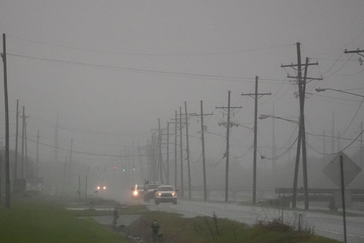 Cars drive through a thick fog outside of New Orleans ahead of Hurricane Francine