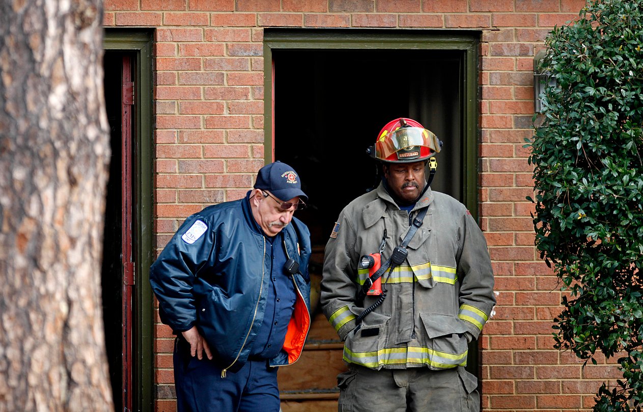 Fire officials standing outside of a building