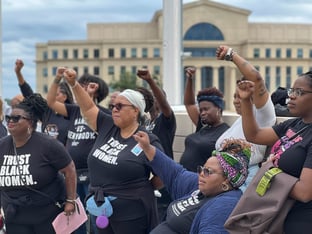 Organizers and supporters of the Trust Black Women initiative, created by reproductive justice group SisterSong, raise their fists at a rally on Saturday, Sept. 28, 2024 outside of the Georgia State Capitol building following recent reports that two Georgia women died after not receiving timely abortion and medical care.
