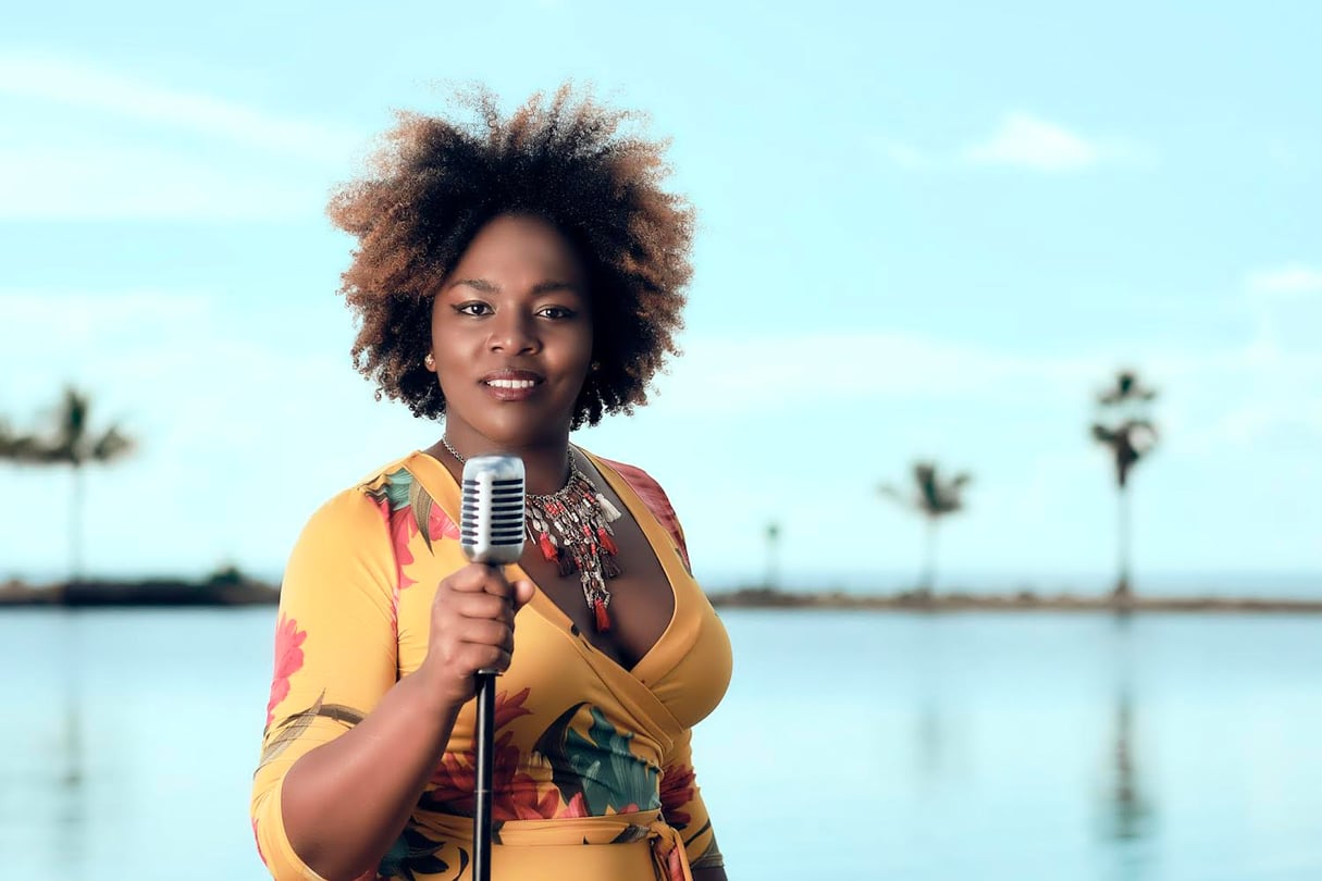 Jessy Diaz holds a microphone in front of a body of water.