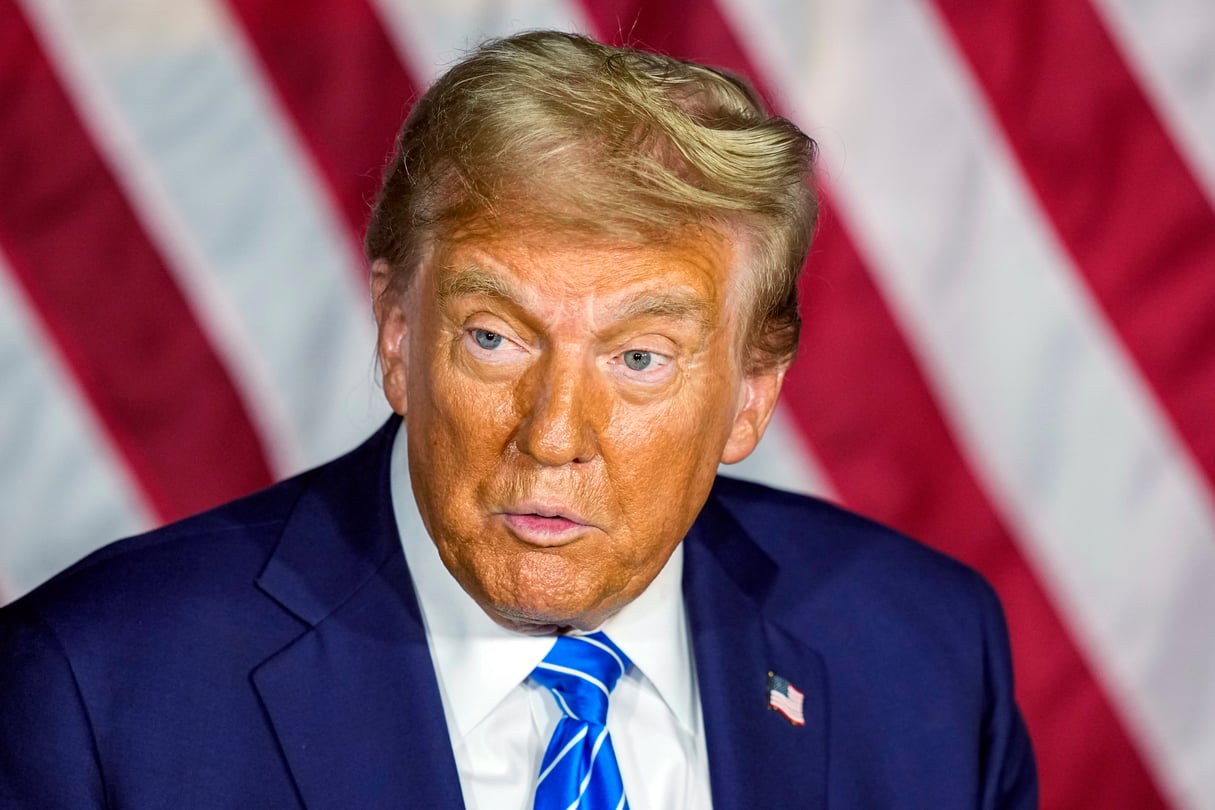 A closeup of Donald Trump's face against the stripes of the American flag.