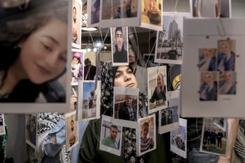 A woman looks at photos hanging from the ceiling of Palestinians who died in the Israel-Hamas war.