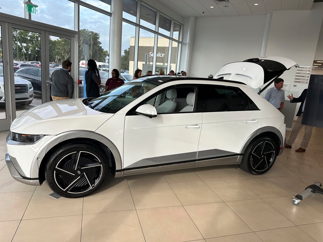 A white Hyundai Ioniq 5 car inside a dealership.