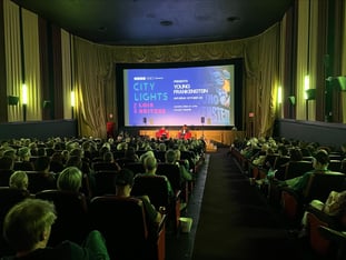 A movie theater with the City Lights logo projected on screen.