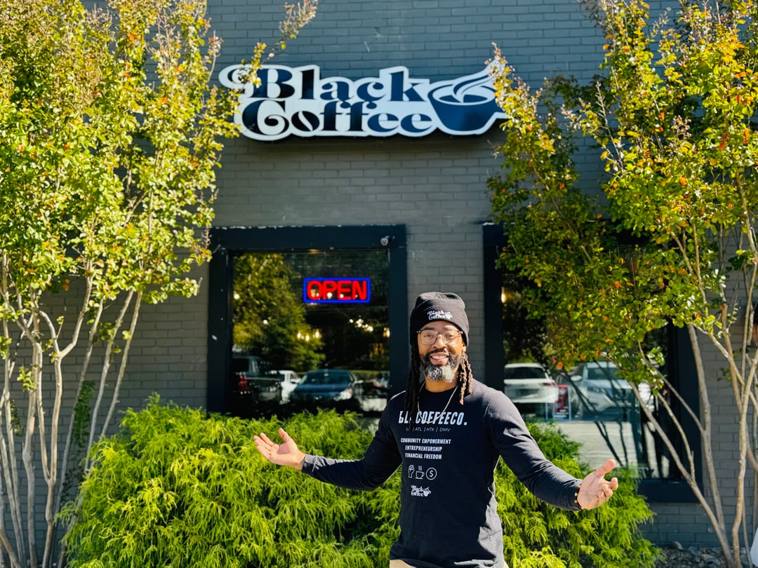 CEO and co-founder Jamin Butler poses in front of Black Coffee Company.