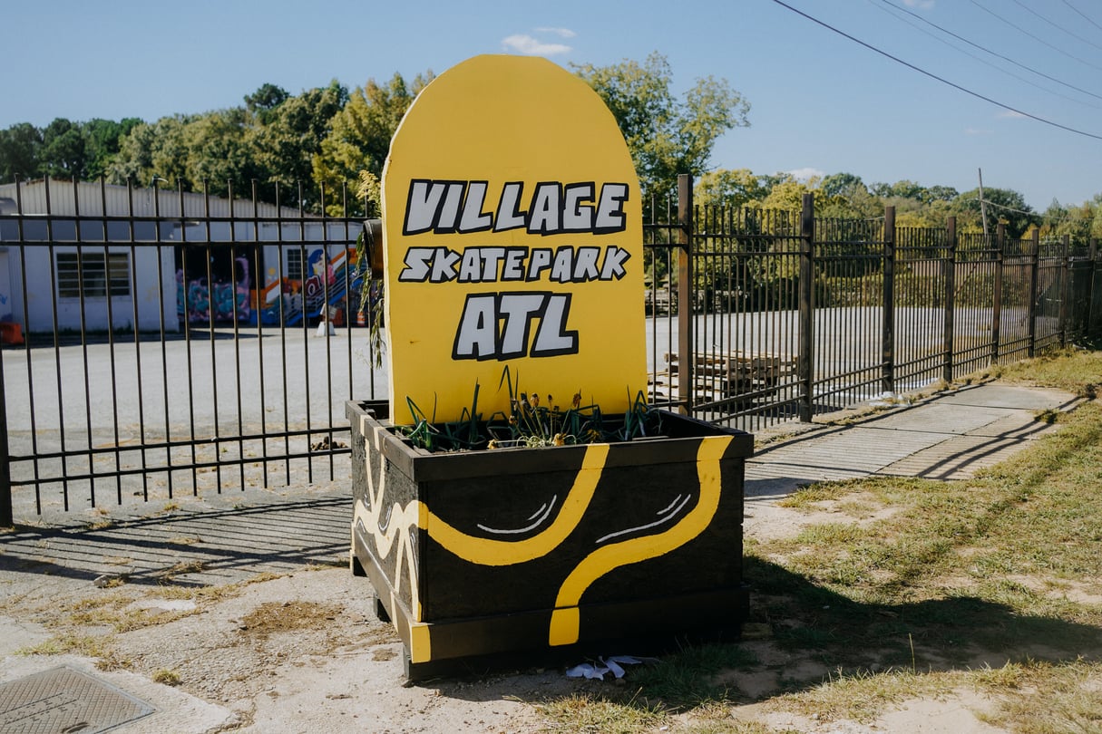 Village Skatepark ATL's new yellow sign in the shape of half of a skateboard.