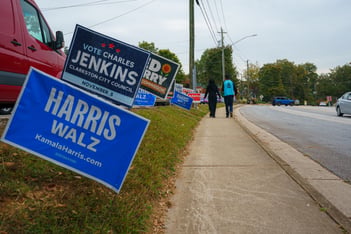 Campaign signs line the streets near the Clarkston Branch of the DeKalb County Public Library on the last day of early voting, Friday, November 1, 2024.
