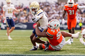Georgia Tech wide receiver Malik Rutherford, left, reaches over the goal line while being tackled by Miami defensive lineman Ahmad Moten Sr.