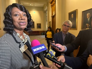 Georgia State House Minority Leader Carolyn Hugley talks to a crowd of reporters holding microphones