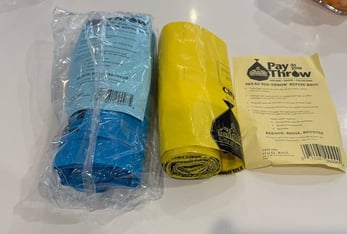 A roll of blue bags and a roll of yellow bags.