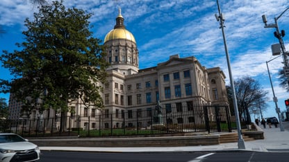 The Georgia State Capitol building is shown on a sunny day