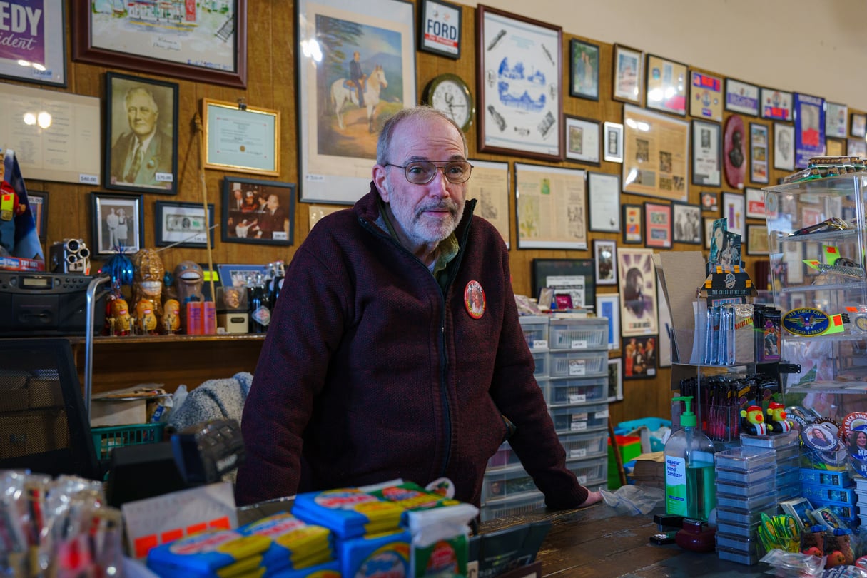 Philip Kurland, the longtime owner of the Plains Trading Post on Main Street, stands amid a sea of pins and memorabilia from past campaigns.