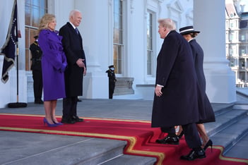 President Joe Biden and First Lady Jill Biden stand on the steps of the White House, facing Donald Trump and Melania Trump as they make their way up the steps.