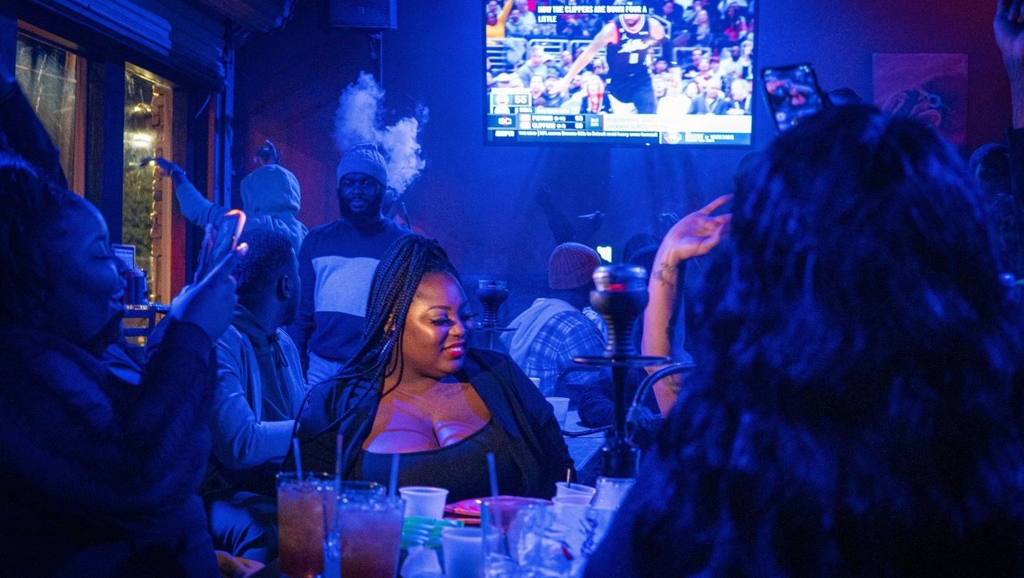 Patrons sitting at a bar under a blue light at Our Bar on Edgewood Avenue in Atlanta.
