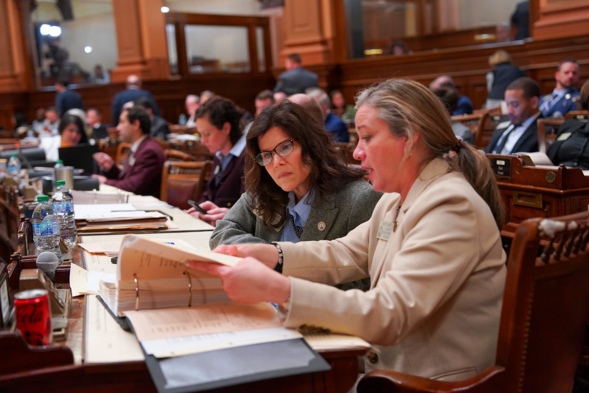 Republican State Rep. Kimberly New and Republican Rep. Beth Camp look at a bill on the House floor.