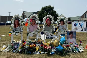 A poster with images of shooting victims in front of Apalachee High School.