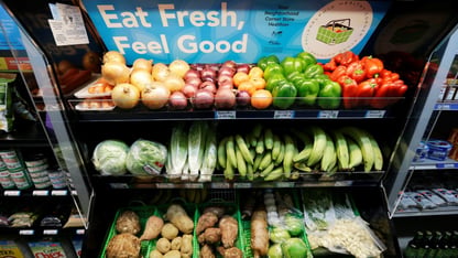 A fresh food stand with vegetables.