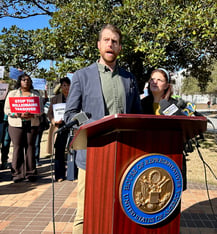 Ryan Sloane, one of hundreds of federal employees fired from the CDC as the Trump administration slashes the government workforce, speaking at a protest in Atlanta. (Jess Mador/WABE)