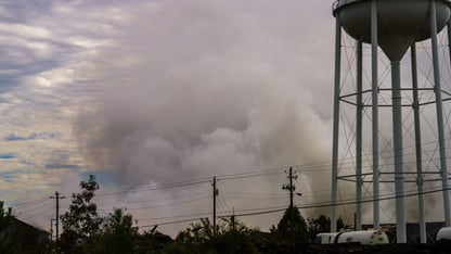 A large plume of smoke near a plant