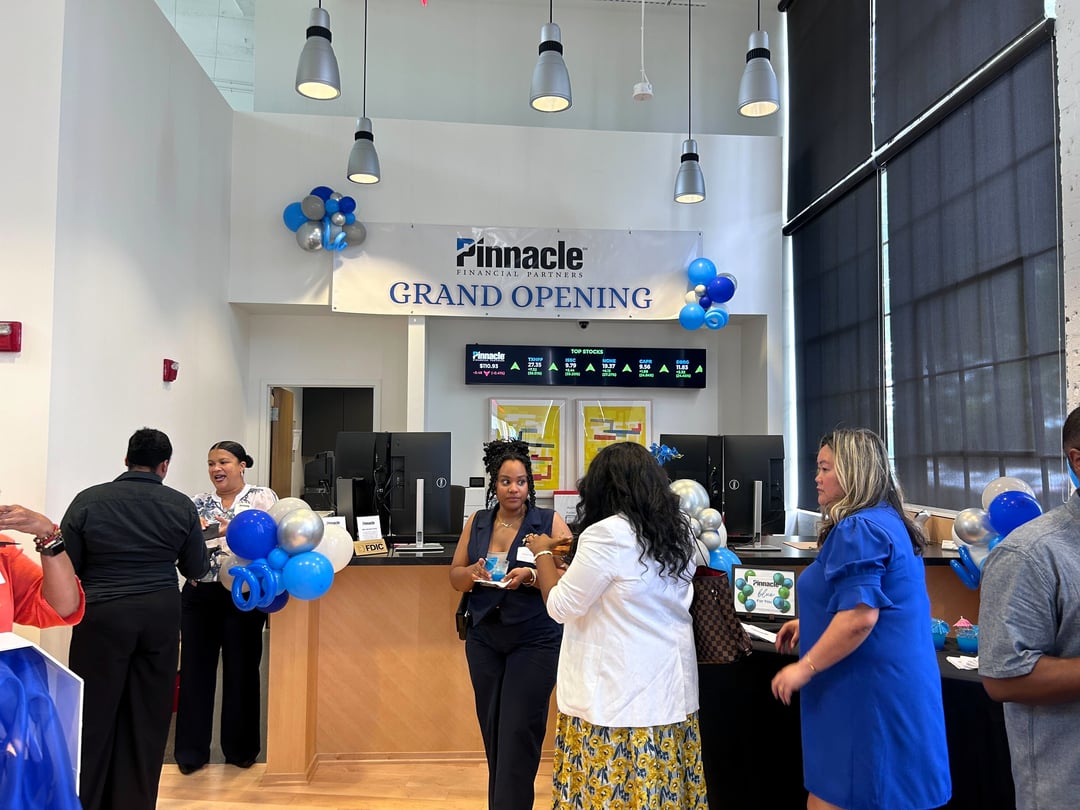 People standing around a bank grand opening.