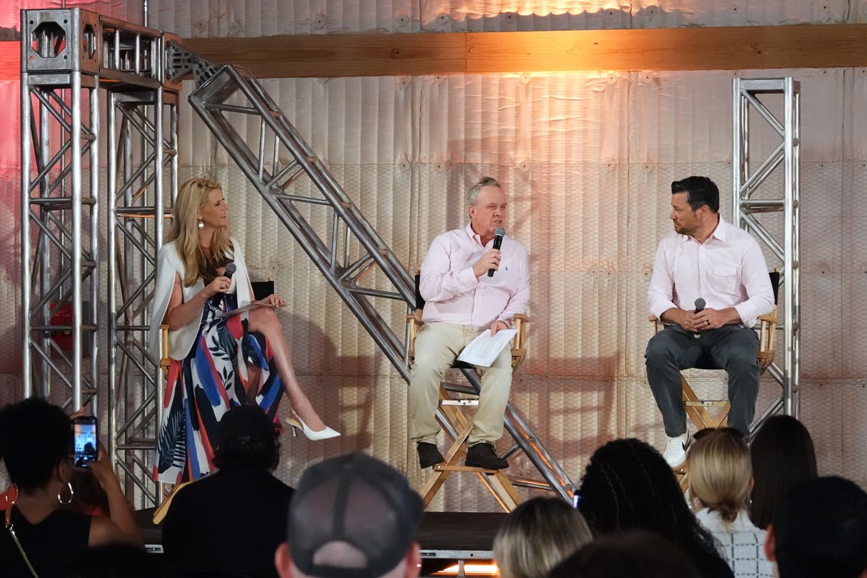 Three people in the film industry sit and talk to a crowd.