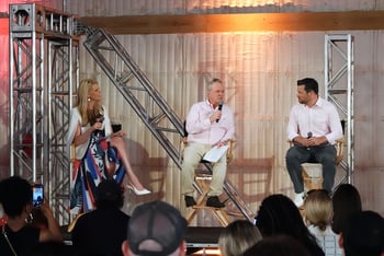 Three people in the film industry sit and talk to a crowd.