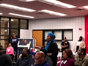 A woman stands up and speaks during a community meeting