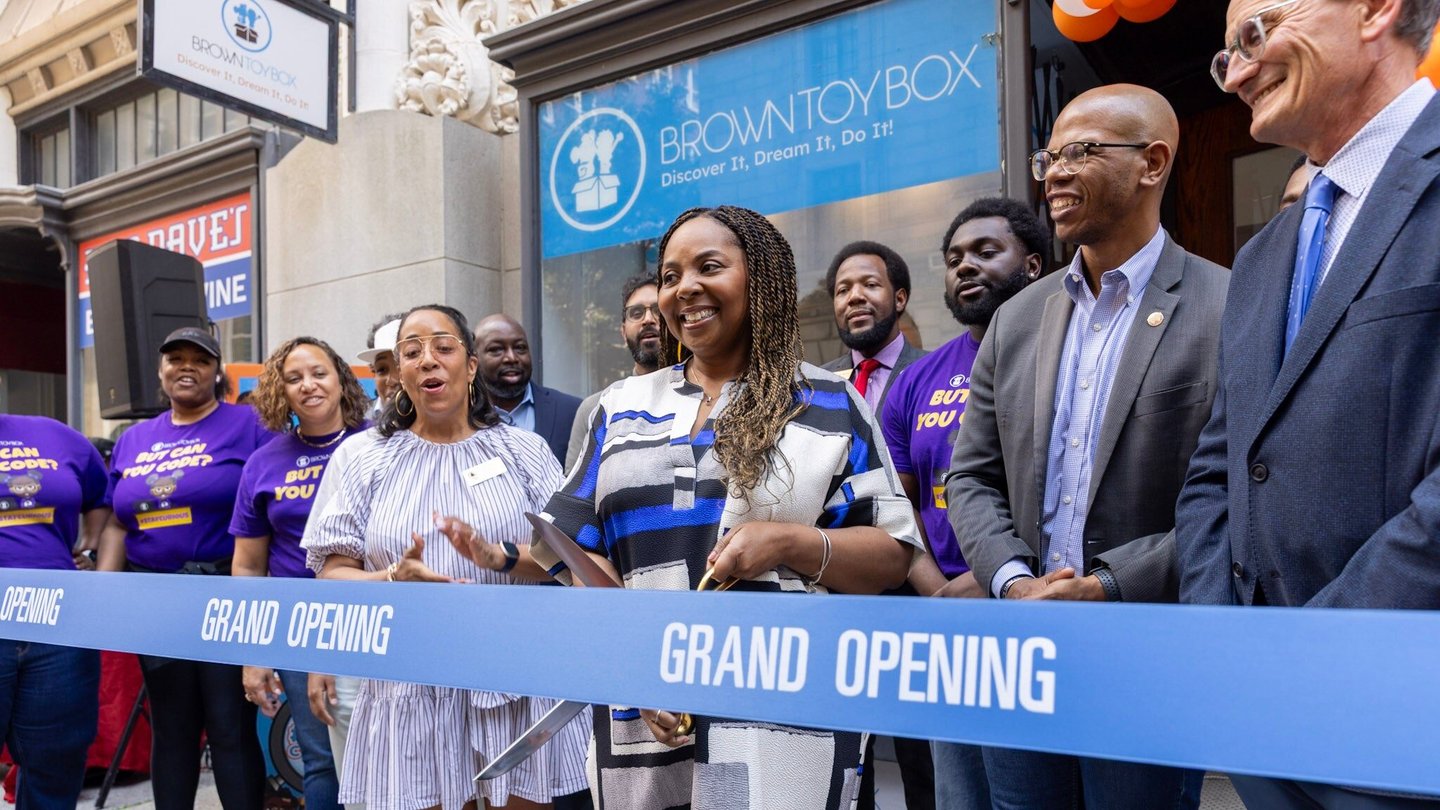 A group of people standing and smiling at a grand opening.