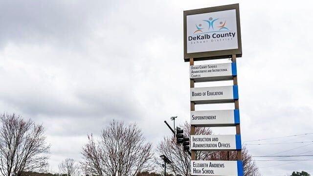 A tall sign displaying the DeKalb County School District logo
