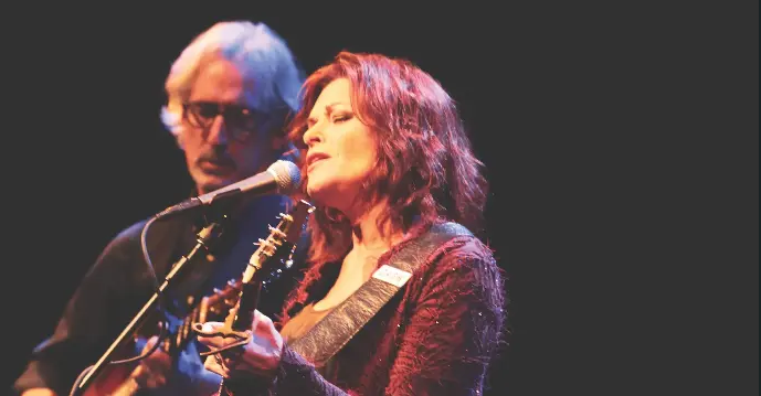 Female singer performs onstage with a guitarist