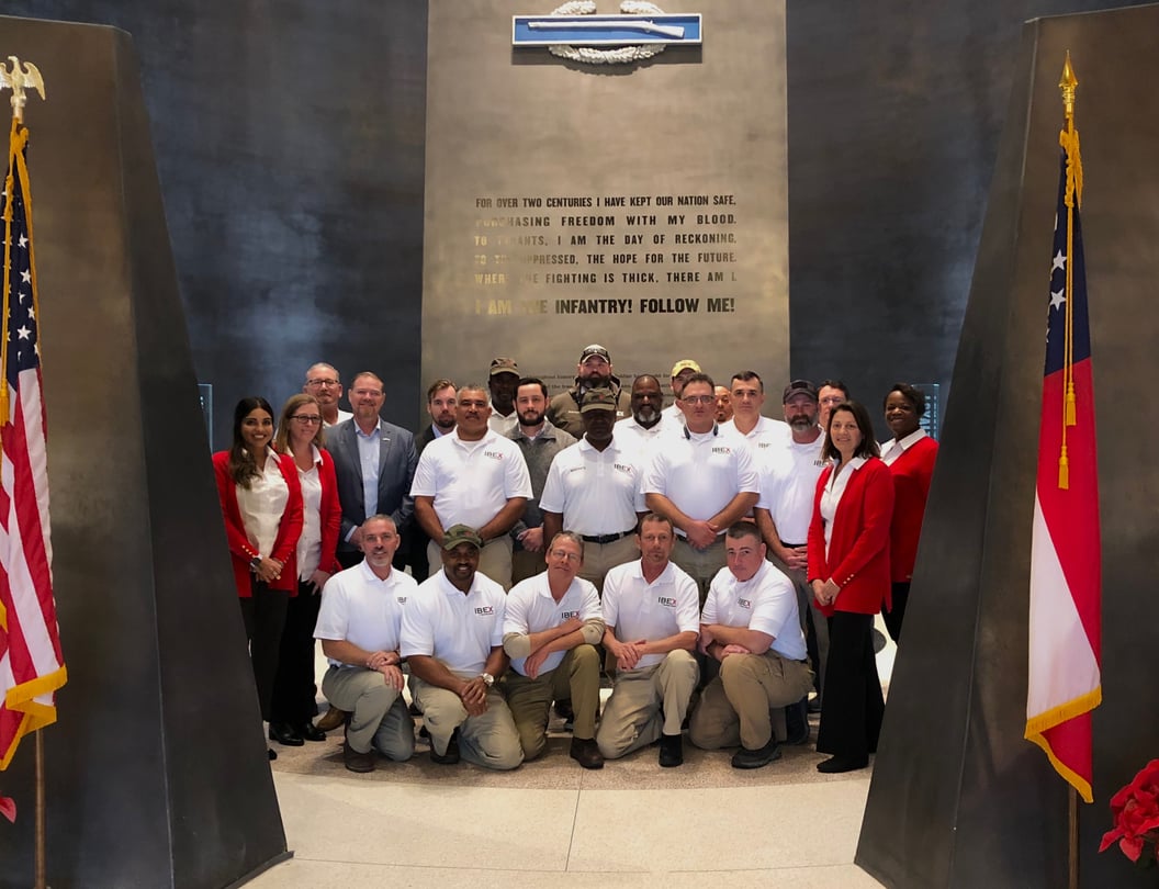 A group of people standing in between two American flags.