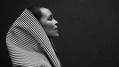 Black-and-white portrait of model Lana Ogilvie in profile wearing a striped hooded garment.