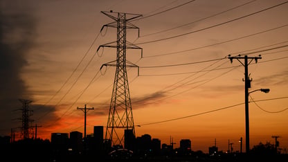 Power lines in front of an orange sunset