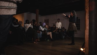 A group of people playing movies for each other as the organizer speaks to the audience.