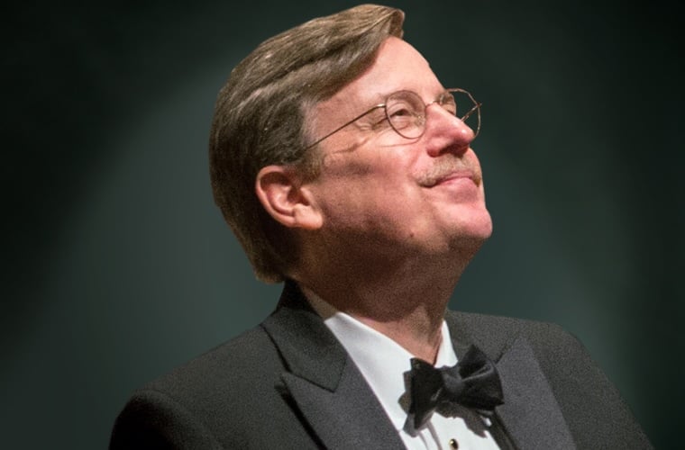 Portrait of Norman Mackenzie in a tuxedo looking up