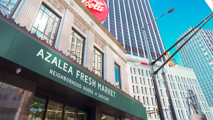 The dark green storefront of the Azalea Fresh Market